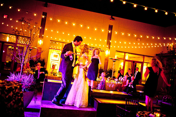 the happy couple having fun on the dance floor at the reception with warm gold lighting shining all around - photo by New Mexico based wedding photographers Twin Lens
